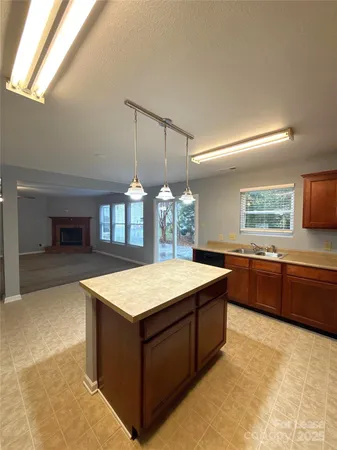 a kitchen with a stove a sink a counter space and a window