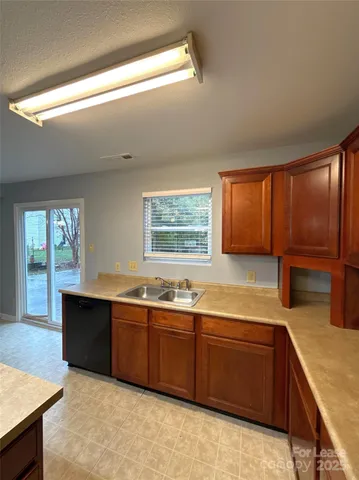a kitchen with stainless steel appliances granite countertop sink window and cabinets