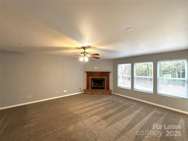 a view of an empty room with a fireplace and a large window