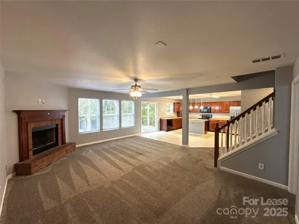 a view of an empty room with a fireplace and windows