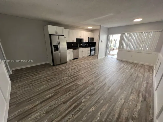 a view of a kitchen with a sink and a refrigerator
