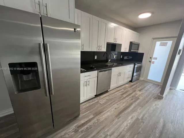 a kitchen with stainless steel appliances a refrigerator sink and microwave
