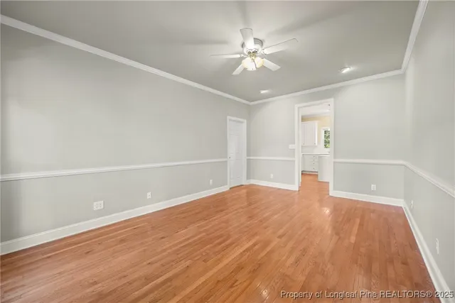 an empty room with windows and ceiling fan