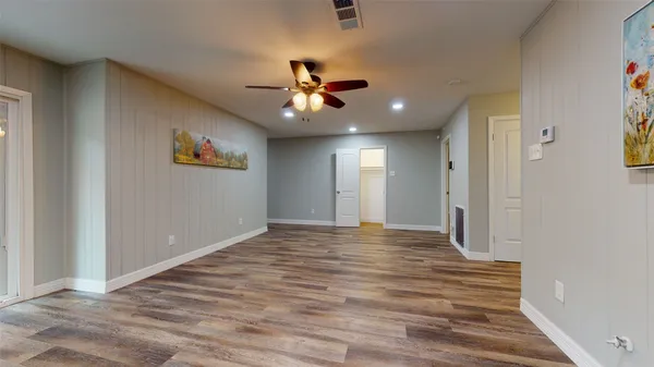 a view of an empty room and window a ceiling fan