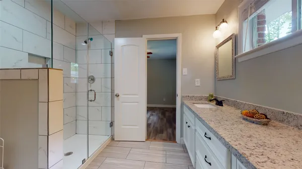 a bathroom with a granite countertop sink mirror and shower
