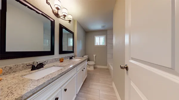a bathroom with a granite countertop sink mirror and double
