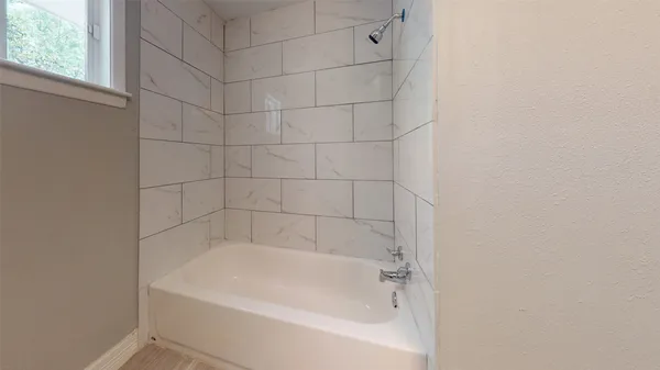 a white bath tub and shower