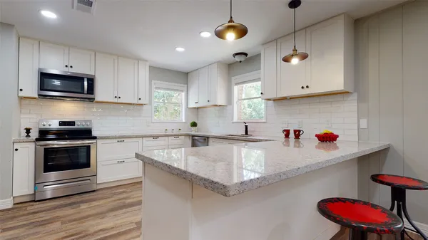 a kitchen with stainless steel appliances granite countertop a sink a stove and a microwave