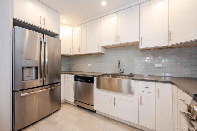 a kitchen with granite countertop white cabinets and stainless steel appliances