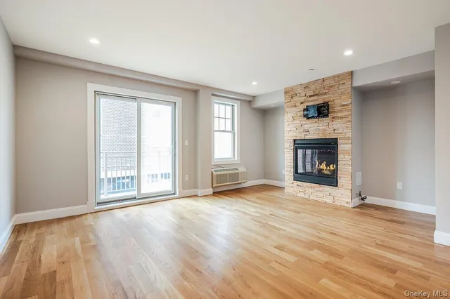 an empty room with windows and fireplace