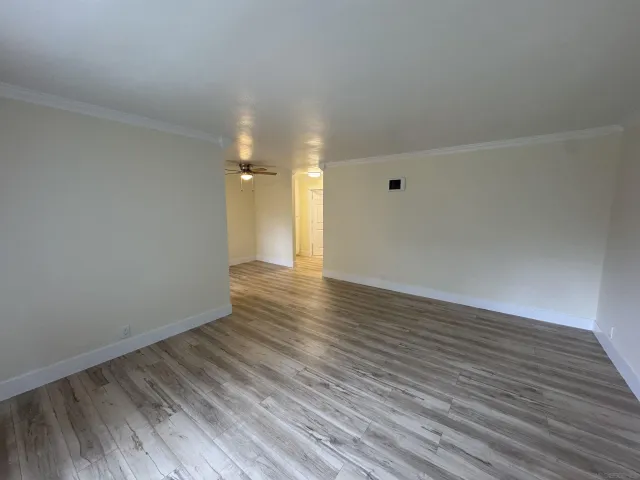 a view of an empty room with wooden floor