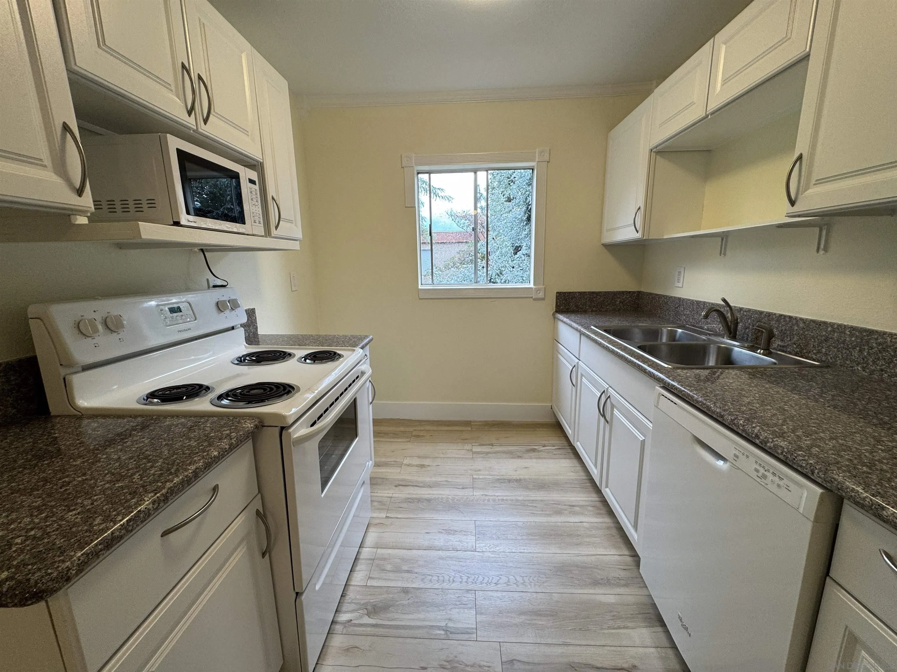 12923 Mapleview Street, Unit 8 Lakeside, CA 92040 - Photo 7 of 25 a kitchen with granite countertop a sink a stove oven and wooden cabinets