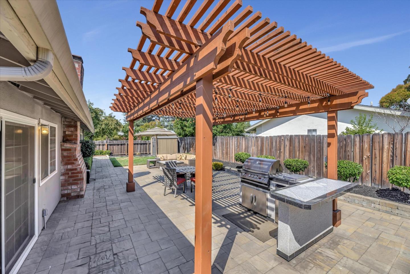 1391 3rd Street Gilroy, CA 95020 - Photo 31 of 40 a view of a patio with table and chairs potted plants with wooden floor and fence