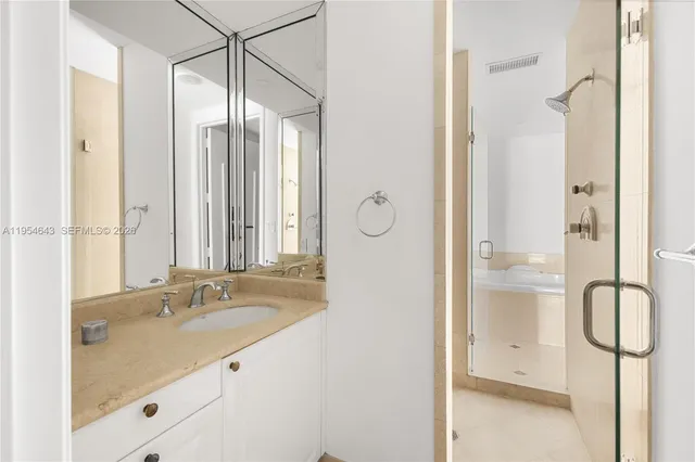 a bathroom with a tub sink and mirror
