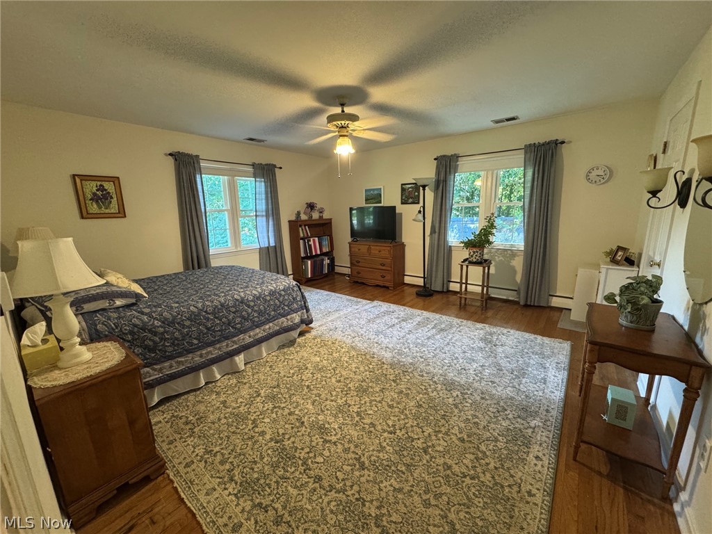 296 Fairfield Road Painesville, OH 44077 - Photo 25 of 48 Spacious room featuring hardwood flooring, multiple windows, and a ceiling fan