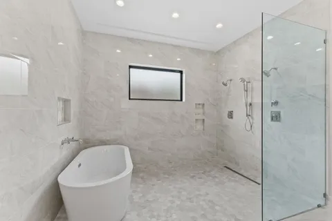 a bathroom with a white bath tub and shower