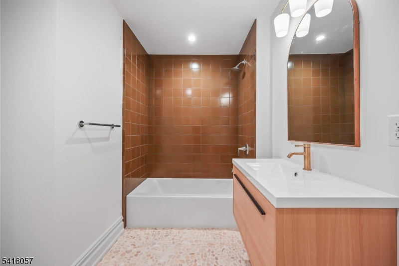 1209 Littleton Road, Unit A Morris Plains, NJ 07950 - Photo 13 of 23 a bathroom with a bathtub a sink and a mirror