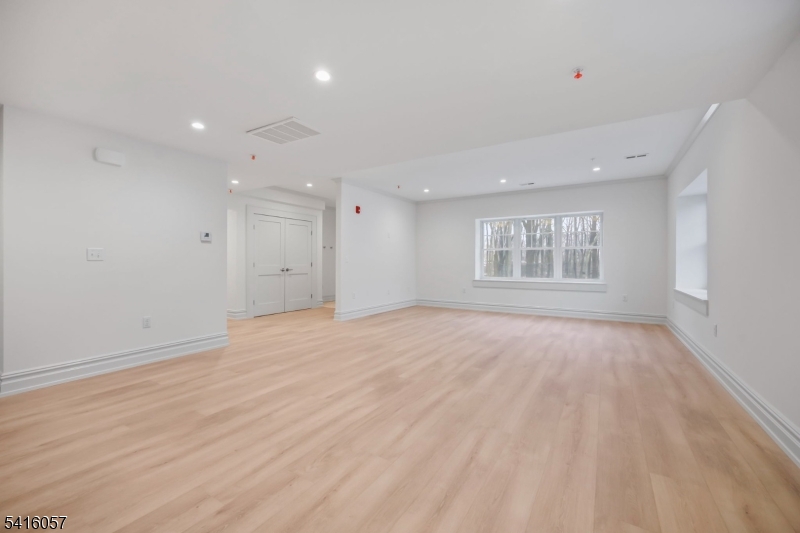 1209 Littleton Road, Unit A Morris Plains, NJ 07950 - Photo 2 of 23 an empty room with wooden floor and windows