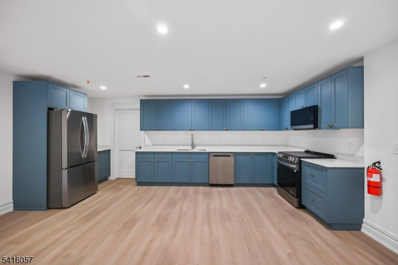 1209 Littleton Road, Unit A Morris Plains, NJ 07950 - Photo 7 of 23 a kitchen with stainless steel appliances kitchen island granite countertop a refrigerator and a stove top oven