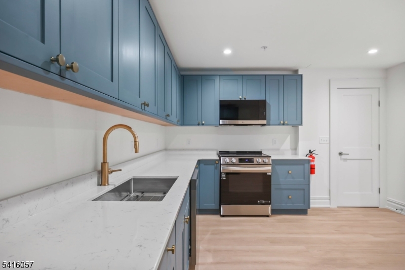 1209 Littleton Road, Unit A Morris Plains, NJ 07950 - Photo 9 of 23 a kitchen with stainless steel appliances granite countertop a white stove top oven and sink