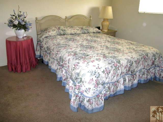 1268 Ramon Road, Unit 52 Palm Springs, CA 92264 - Photo 17 of 22 a bed sitting in a bedroom next to a lamp