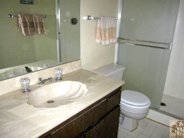 1268 Ramon Road, Unit 52 Palm Springs, CA 92264 - Photo 19 of 22 a bathroom with a granite countertop sink toilet and a mirror