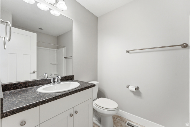 1614 Aspen Loop Provo, UT 84606 - Photo 20 of 47 Bathroom featuring a white vanity with double-door cabinetry, a speckled dark countertop, and a built-in oval sink with a chrome faucet