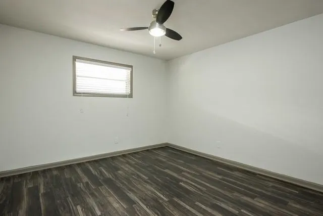 a view of a room with wooden floor and ceiling fan