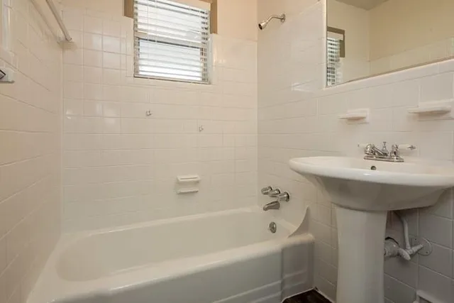 a bathroom with a sink a bathtub and a window