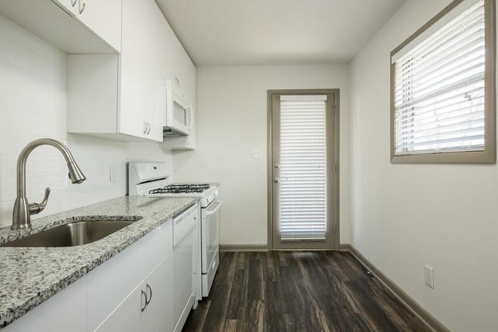 921 Myrtle Street Northeast, Unit MYRT006 Atlanta, GA 30309 - Photo 6 of 21 a kitchen with a sink cabinets a stove and wooden floor