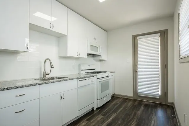 a kitchen with stainless steel appliances granite countertop a sink stove and cabinets