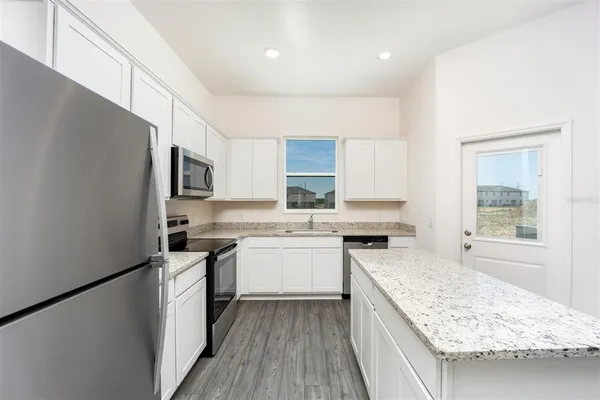 a kitchen with a sink stove top oven and refrigerator