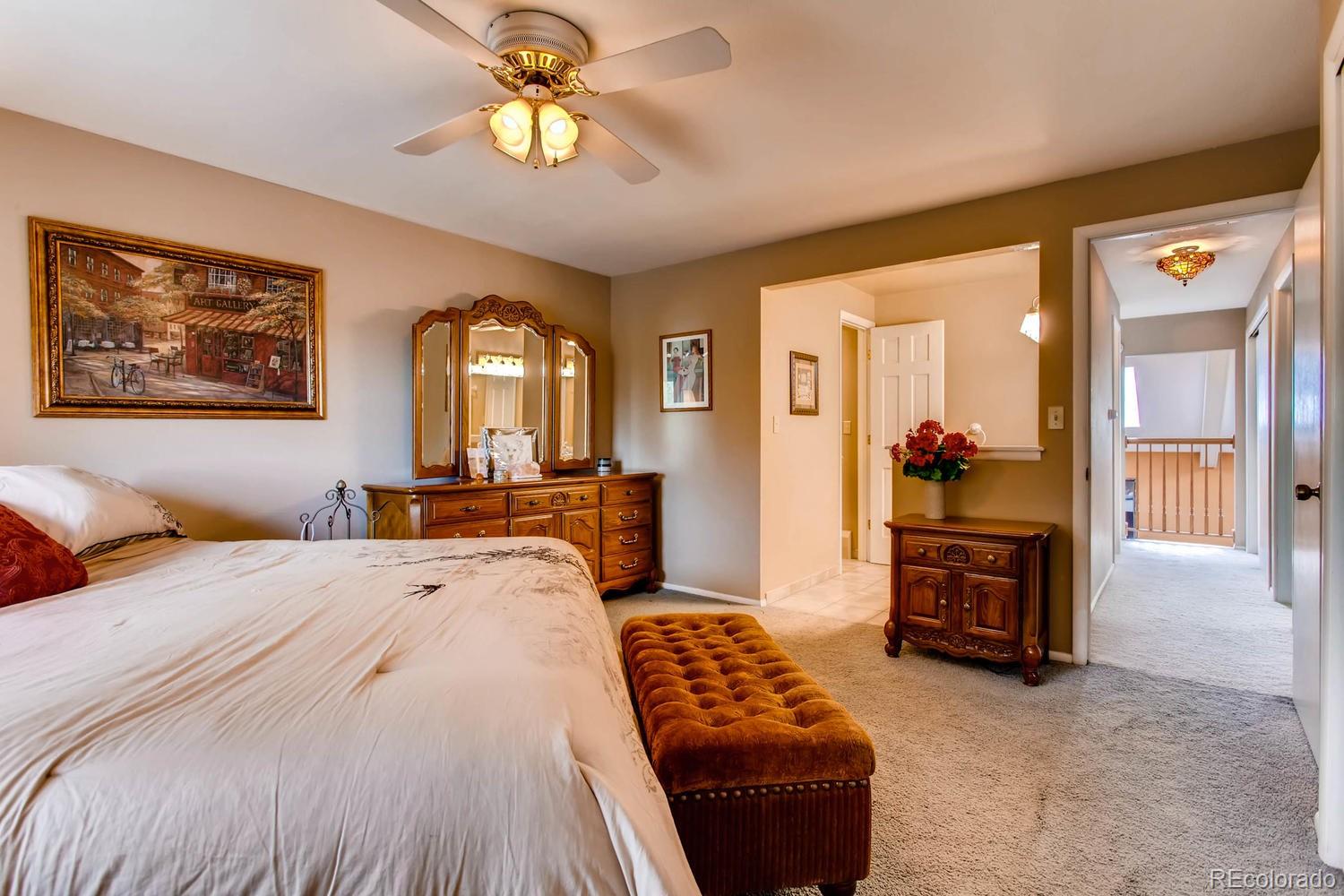 1926 Foothills Road Golden, CO 80401 - Photo 16 of 28 a spacious bedroom with a bed a dresser and a chandelier
