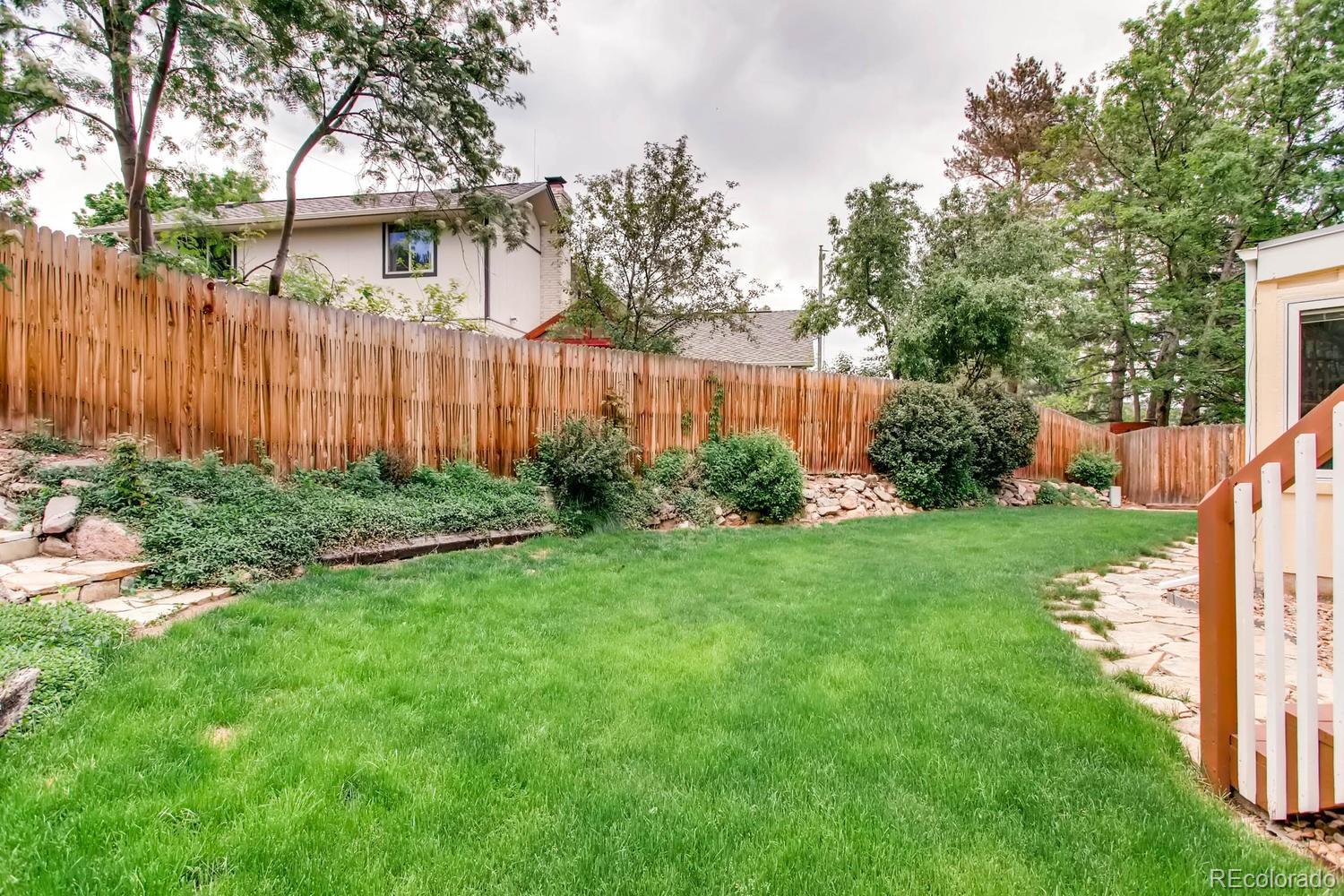 1926 Foothills Road Golden, CO 80401 - Photo 26 of 28 a view of a backyard with potted plants and wooden fence