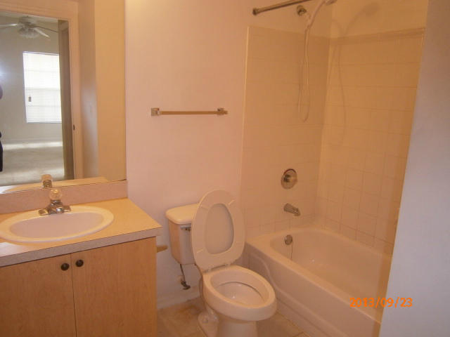 10312 Fox Trail Road South, Unit 1014 West Palm Beach, FL 33411 - Photo 11 of 12 a bathroom with a granite countertop toilet a sink and a bathtub