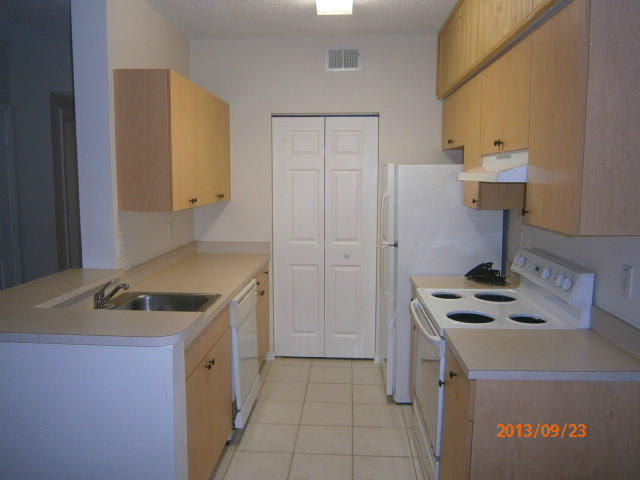 10312 Fox Trail Road South, Unit 1014 West Palm Beach, FL 33411 - Photo 6 of 12 a kitchen that has a sink and a stove in it