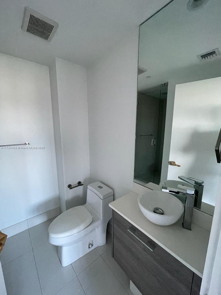 650 Northeast 32nd Street, Unit 1805 Miami, FL 33137 - Photo 13 of 21 a bathroom with a sink toilet and mirror