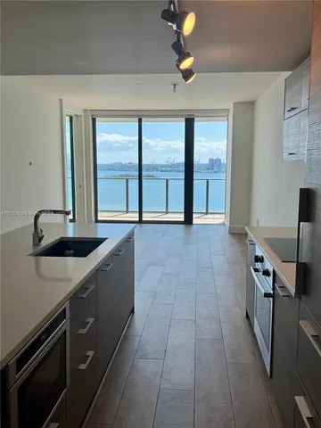 a view of a kitchen with a sink stainless steel appliances and cabinets