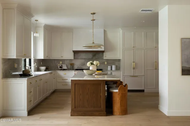 a kitchen with stainless steel appliances granite countertop a sink a stove and a refrigerator