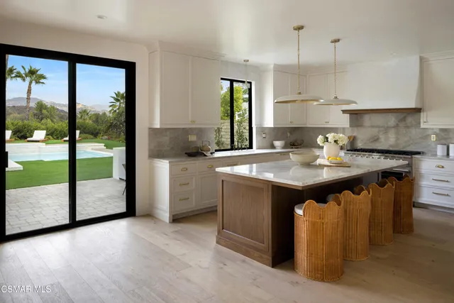a kitchen with a sink a counter top space cabinets and stainless steel appliances