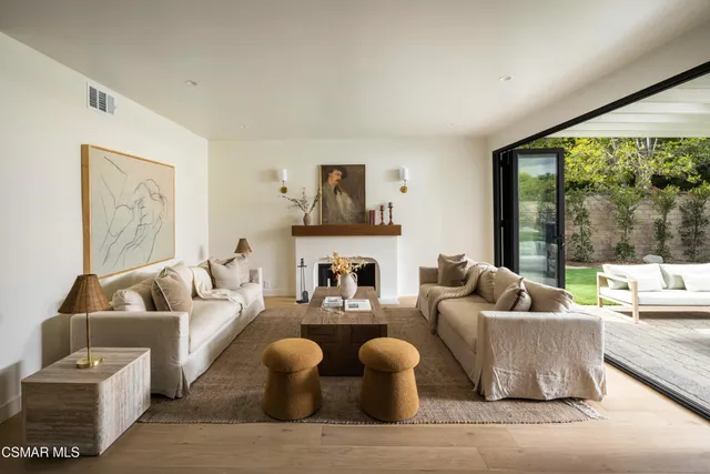 a living room with fireplace furniture and a large window