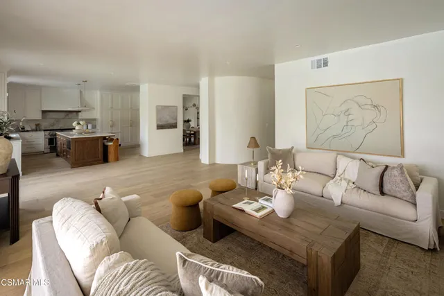 a living room with furniture and view of kitchen