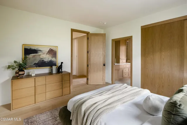 a bedroom with a bed and a painting on the wall