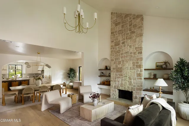 a living room with furniture a fireplace and a chandelier