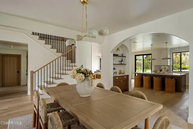 a view of a dining room and livingroom with furniture wooden floor a chandelier