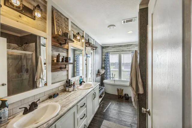 a bathroom with a double vanity sink a mirror and a shower