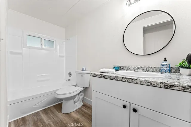 a bathroom with a granite countertop toilet sink and mirror