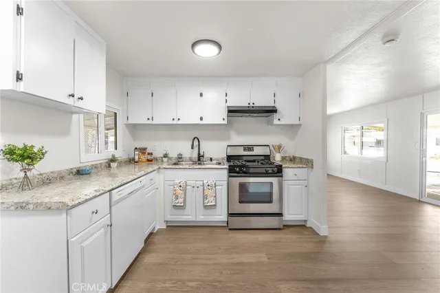 a kitchen with stainless steel appliances granite countertop a sink and stove top oven