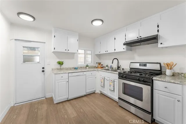 a kitchen with granite countertop white cabinets and white appliances