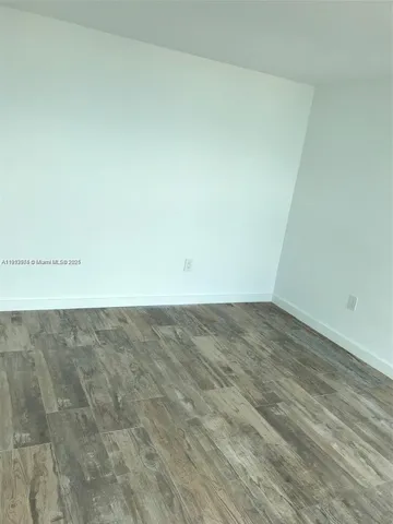 a view of an empty room with a fireplace and a window